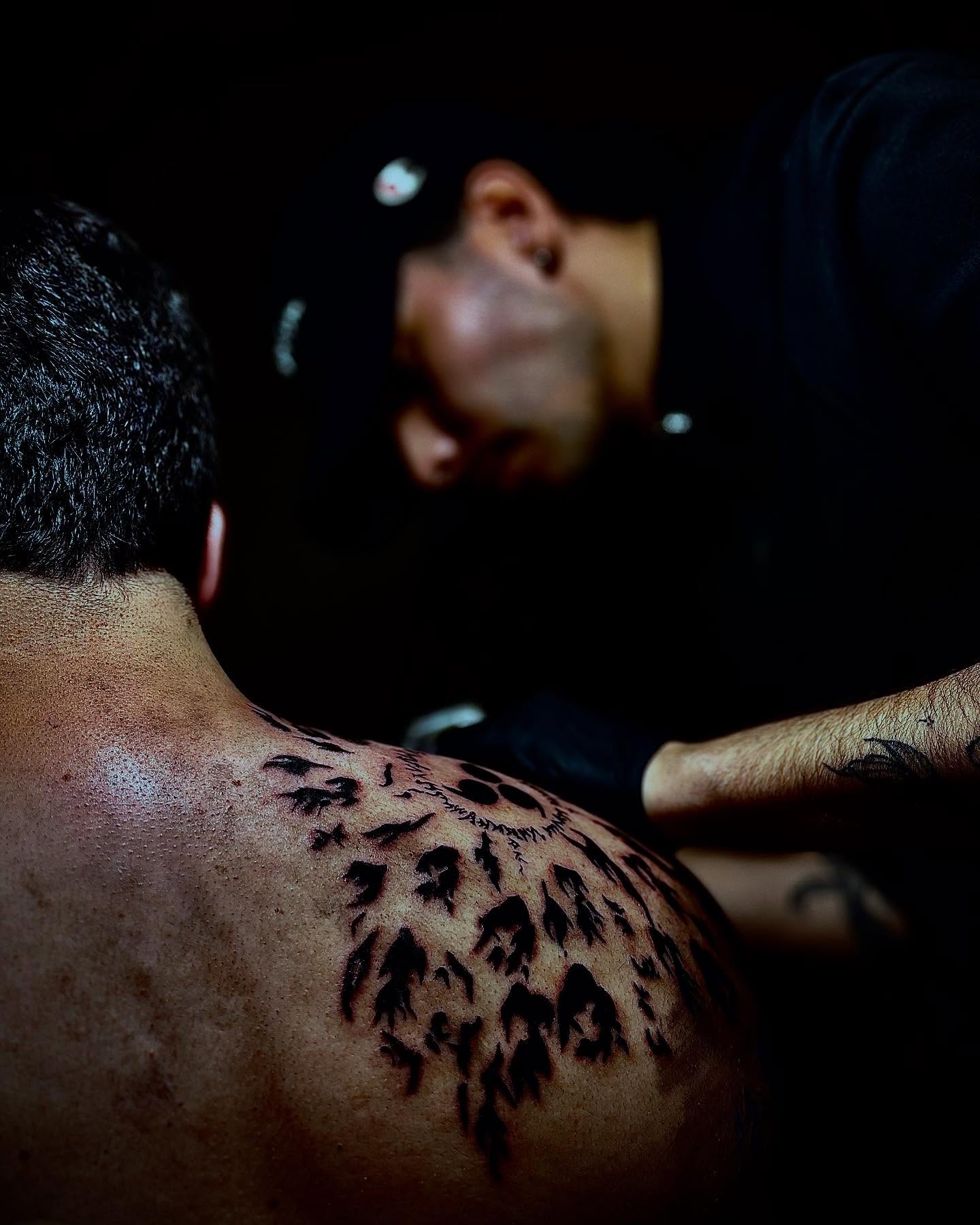 Tatuador en su estudio privado concentrado en el trabajo
