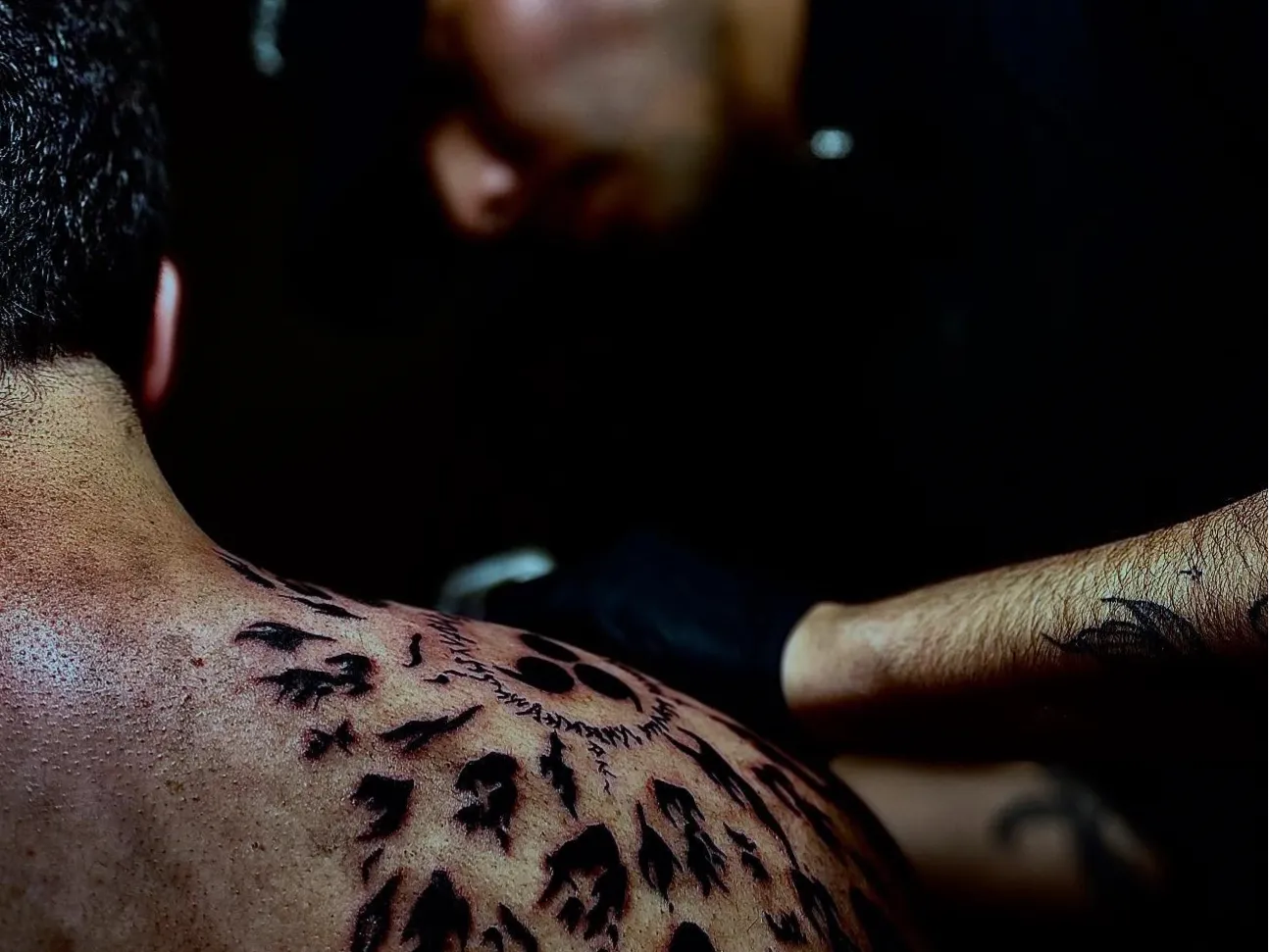 Tatuador trabajando en un tatuaje detallado